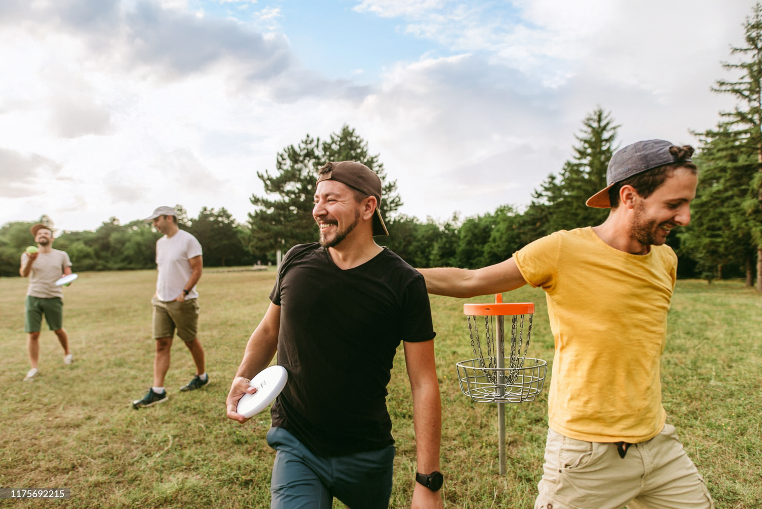 A group of men playing disc golf
